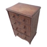 An unusual early 19th century oak chest of small proportions; the slightly overhanging top carved to