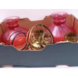 A pair of wall-mounting brass oil lamps with cranberry glass shades (shades approx. 22 cm diameter)