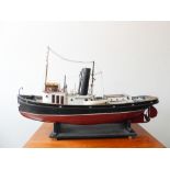 A custom-built model of a Thames Tug (108cm long x 28cm widest) resting upon a black painted