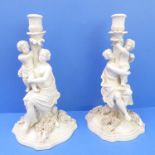 A pair of late 19th century opposing porcelain figural candlesticks; the bases decorated with