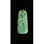 A Chinese green jadeite pendant; each side carved with a feng amongst foliage and flowerheads,