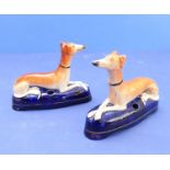 A pair of 19th century Staffordshire inkwells modelled as recumbent longdogs