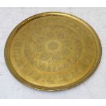 An early 20th century circular brass Benares-style tray; bordered with Islamic script within varying