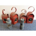 An interesting selection of six lamps comprising four red-painted roadwork lamps and two, possibly