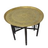 An early 20th century Eastern circular brass tapped table on folding base with spindles, various