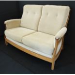 An Ercol light-elm show-wood upholstered two-seater sofa (approx. 152cm wide x 77cm deep x 97cm