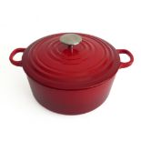 A red Le Creuset-style iron casserole pot in as new condition (22.5cm diameter not including