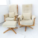 A pair of Ercol light-elm upholstered swivel armchairs (some staining and wear to upholstery) and