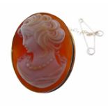 An oval cameo brooch caved with a shoulder length portrait of a maiden in profile with curly hair