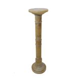 An early 20th century circular onyx torchère stand; annulated column and on spreading circular