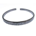 A heavy hallmarked silver bangle engraved with alternating fish and starfish