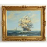 In the style of Montague Dawson; a gilt framed oil on canvas study of clippers at sea, signed