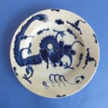 A Lowestoft dish decorated in deep cobalt blue with a four-clawed dragon chasing the flaming pearl