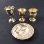 Four pieces of hallmarked silver: three egg cups (one with weighted base and another with Celtic-