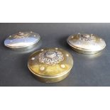 A pair of ornate circular silver-plated boxes and covers: the covers decorated in Eastern style (
