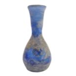 An early style light-blue glass flask of baluster form: waisted neck above two stylised flowerhead