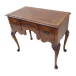 An early 18th century style walnut lowboy (probably mid 20th century): the figured walnut, feather