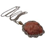 An 18-carat white gold carved coral and diamond pendant with diamond bale