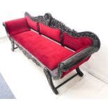 A large 19th century ebony sofa (possibly Ceylonese): the high central carved scallop-shell-style