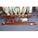 A pair of double curtain poles; the poles made of fluted stained oak with gilded details and