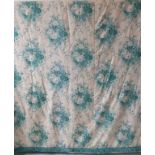 A pair of curtains in a cream and green patterned silk effect damask with a green floral print,