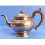 A hallmarked silver teapot with carved wooden handle and turned finial, maker's mark SD Ld,