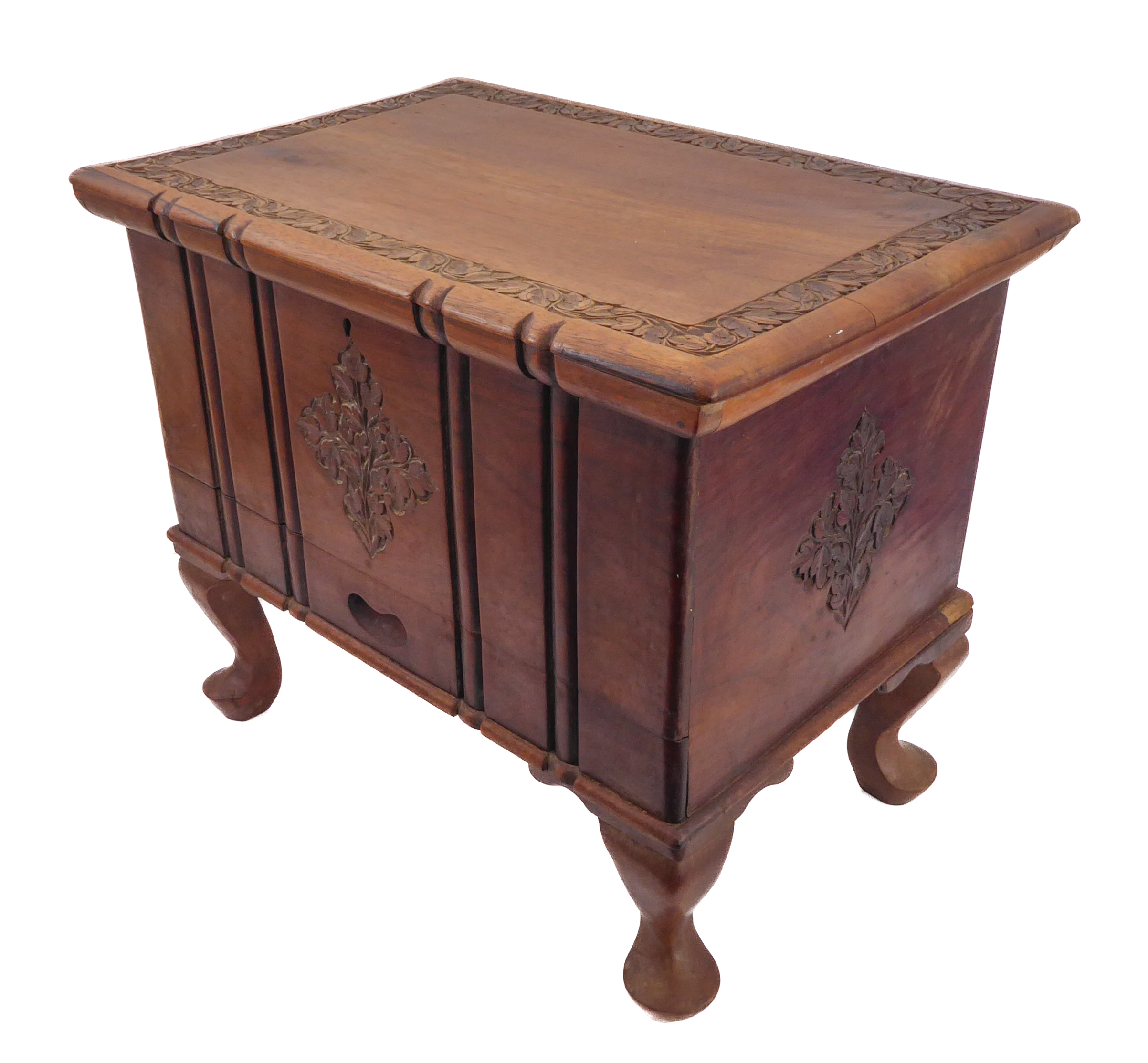 A small carved Eastern hardwood chest: the overhanging top above a pull-out top compartment