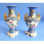 A pair of 19th century French porcelain vases: each with two gilt handles and vignettes of floral