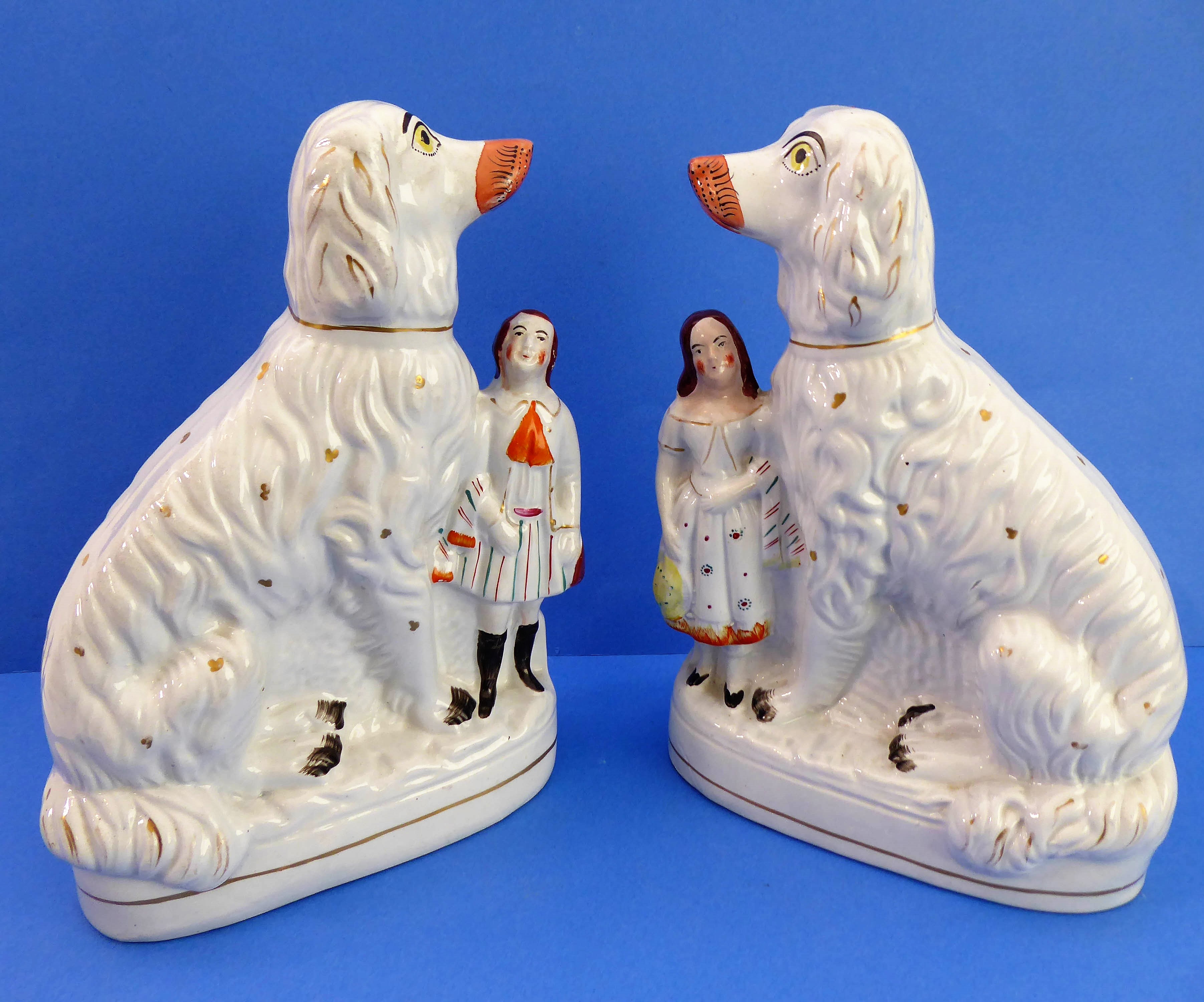 A large and rare pair of Staffordshire spaniels with male and female figure attached.