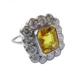 An 18-carat white gold ring set with a 3 carat yellow sapphire surrounded by 1.5 carats diamonds,