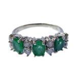 An emerald and diamond-set ring set with three oval mixed-cut emeralds and separated by four pairs