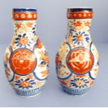A matched pair of late 19th century Japanese vases decorated in the Imari palette (one vase