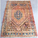 A mid-20th century Kurdish rug; large medallion, rose-red ground with two 'pointed' teardrop