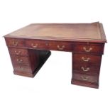 An early 20th century mahogany pedestal desk: thumbnail moulded top with inset gilt-tooled leather