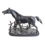A large and heavy painted cast-iron model of a baying stallion standing four-square aside a fence,