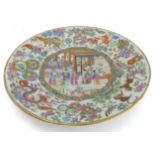 A 19th century Chinese Canton porcelain charger: hand decorated in famille rose palette with a