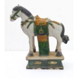 A large and heavy Tang-style Chinese pottery horse: typical green and mustard glazes and with