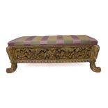 An unusual 19th century carved giltwood long low stool: the pierced friezes with scrolling foliage