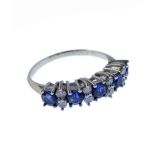 A sapphire and diamond-set ring, the five circular mixed-cut sapphires each set by a pair of