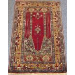 A modern hand-knotted Turkish Kirsehir prayer rug; two vertical mosque pillars and hanging lamp