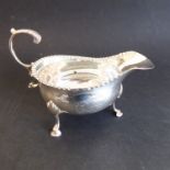 A late 18th century George III period hallmarked silver sauceboat with leaf-capped scrolling