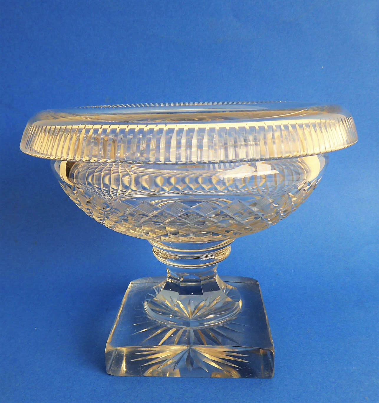 An early 19th century circular pedestal glass bowl: the averted, fluted lip above a hobnail-cut body