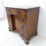 A mid-18th century style (later) mahogany kneehole desk: the flame veneered and crossbanded