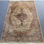 1 A modern wool Kashmiri carpet with central round floral medallion against a light-coloured ground,