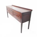 An 18th century oak dresser base of good colour: the galleried moulded top above three mahogany