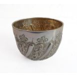 A hallmarked silver sugar bowl decorated repoussé style with scrolling foliate designs, gilded