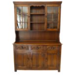 A good reproduction solid oak dresser: the cornice above central shelf space and flanked by two