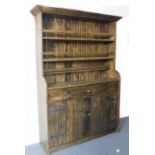 A 19th century style (made from old wood) single piece pine dresser: the flaring cornice above plate