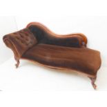 A mid-19th century mahogany show-wood-framed chaise longue; scrolling back, button-back headrest and