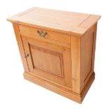 A reproduction style solid light oak side cabinet: the overhanging top with cleated ends above a